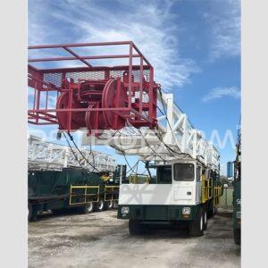 Taladro de reacondicionamiento Workover Lanco 550 DD de 250000 lbs año 2008 montado sobre chasis carrier con mástil telescópico y bloque de corona de poleas rojo